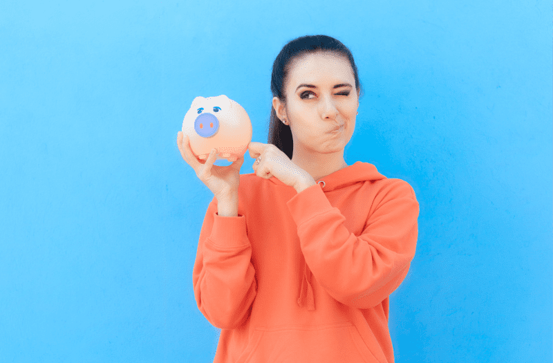 Mujer mostrando una alcancía en donde se encuentra el ahorro para su educación